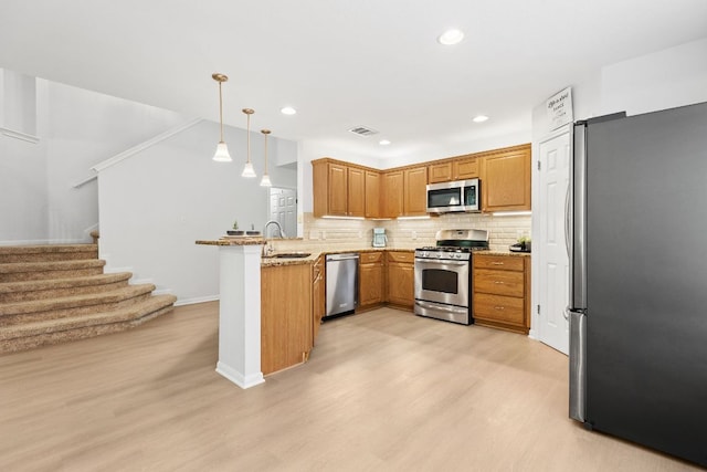 2104 Faldo Ln, Round Rock, TX 78664 - kitchen with appliances with stainless steel finishes, a peninsula, a sink, light wood-style flooring, and recessed lighting