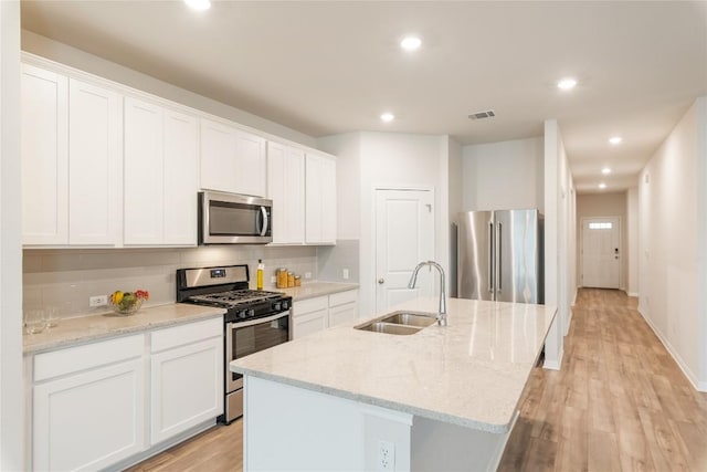 kitchen featuring a sink, light wood-style floors, an island with sink, stainless steel appliances, and recessed lighting