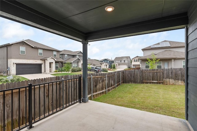 view of patio / terrace with an attached garage, a fenced backyard, a residential view, and concrete driveway