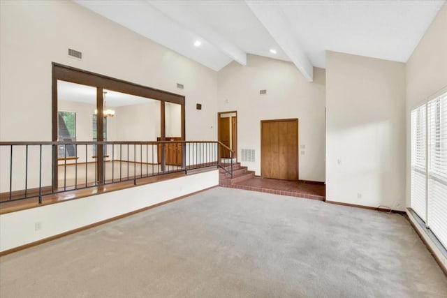 carpeted empty room featuring visible vents, high vaulted ceiling, baseboards, beamed ceiling, and an inviting chandelier