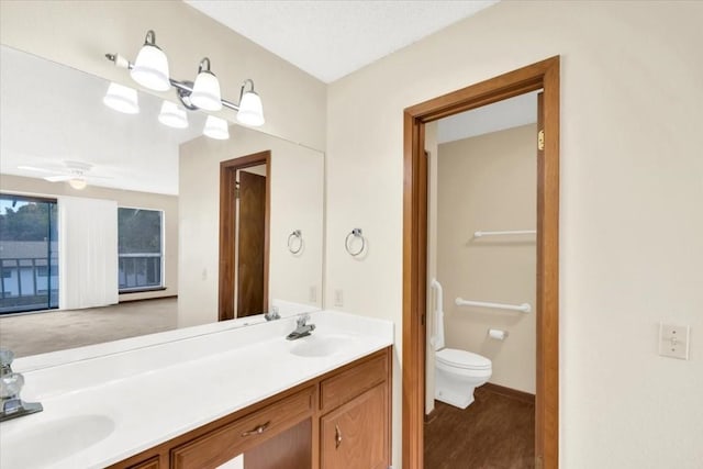 bathroom featuring double vanity, toilet, and a sink