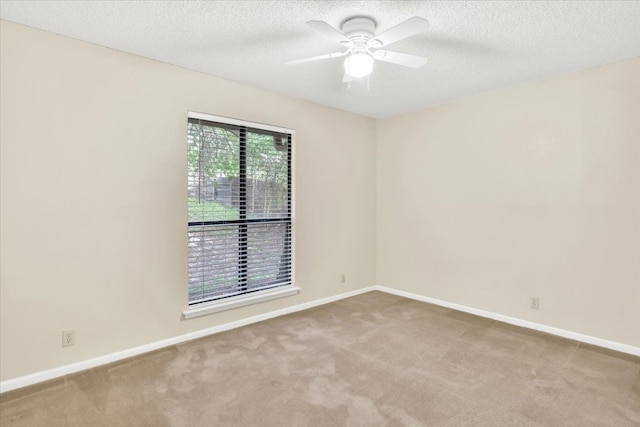 unfurnished room with a textured ceiling, baseboards, and carpet