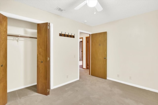 unfurnished bedroom with carpet flooring, a ceiling fan, baseboards, visible vents, and a closet