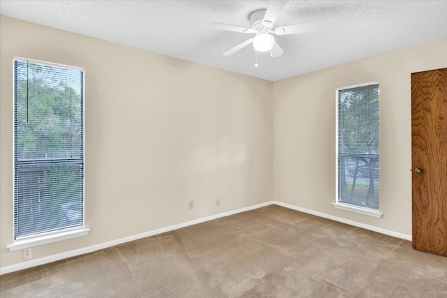 empty room with baseboards, carpet flooring, a textured ceiling, and a ceiling fan