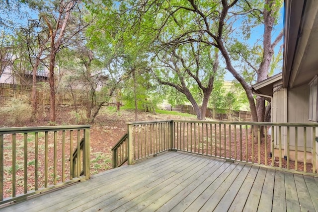 wooden terrace with a fenced backyard