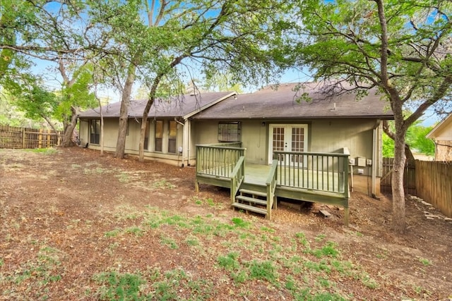 rear view of property with french doors, a shingled roof, a fenced backyard, and a deck