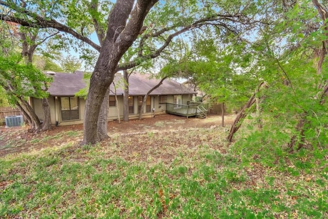 view of yard with a wooden deck, fence, and cooling unit