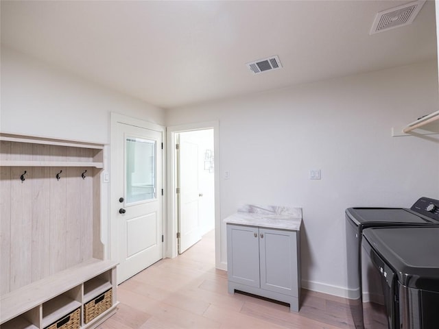 11224 Pickard Ln, Austin, TX 78748 - washroom featuring separate washer and dryer, cabinet space, and light wood finished floors