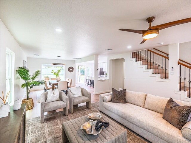 living room featuring recessed lighting, a ceiling fan, stairs, and wood finished floors