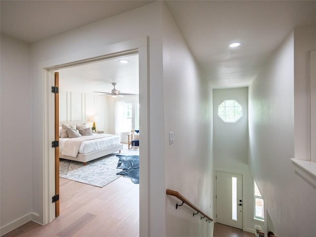 hallway with recessed lighting, light wood finished floors, and baseboards
