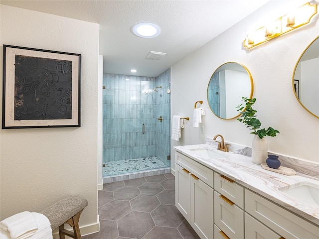 bathroom featuring a sink, tile patterned flooring, a shower stall, and double vanity