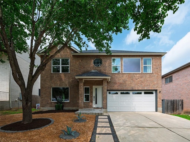 traditional-style home featuring a garage, fence, concrete driveway, and brick siding