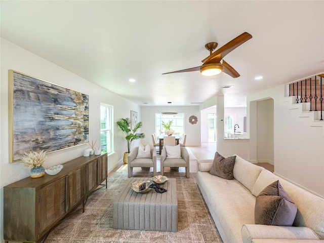 living area with a ceiling fan, baseboards, recessed lighting, and stairway