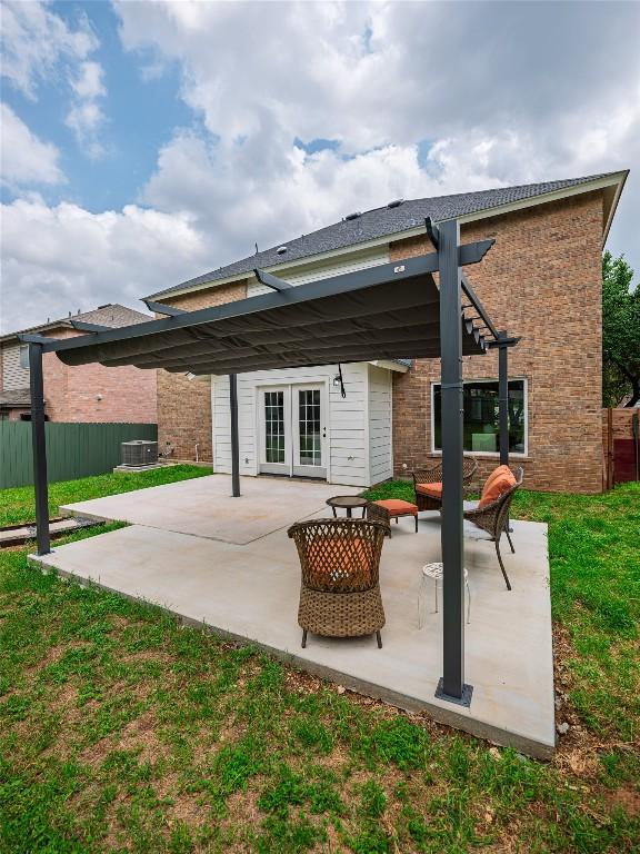back of house with french doors, brick siding, fence, a patio, and a pergola