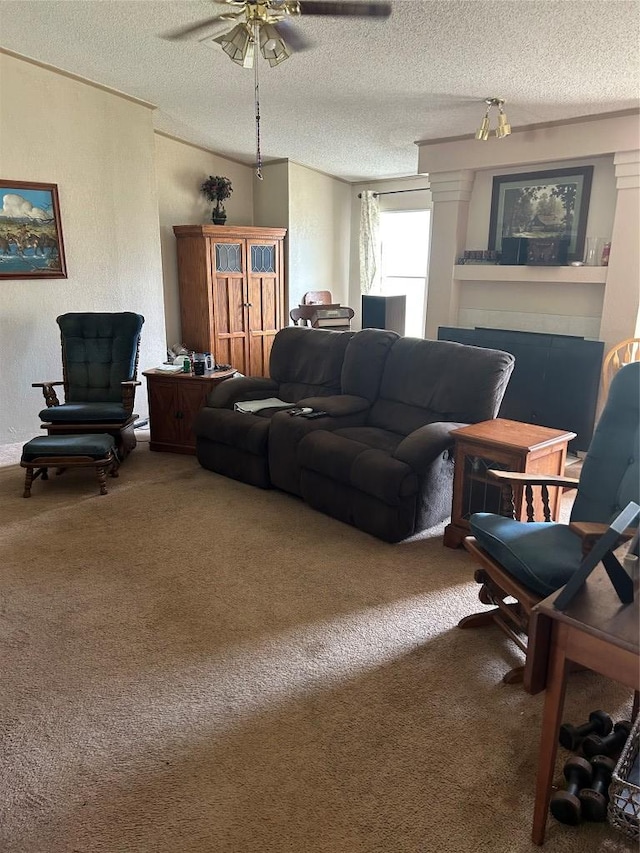 living area with ceiling fan, carpet, and a textured ceiling