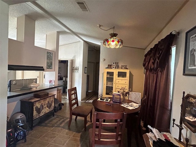dining area featuring a textured ceiling and visible vents