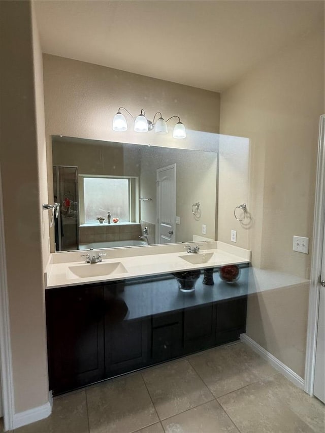 bathroom featuring baseboards, double vanity, tile patterned floors, and a sink