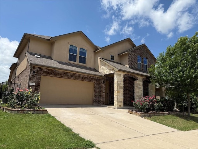 traditional home featuring a garage, brick siding, concrete driveway, stone siding, and stucco siding