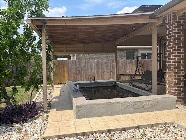 view of patio featuring fence and an outdoor hot tub