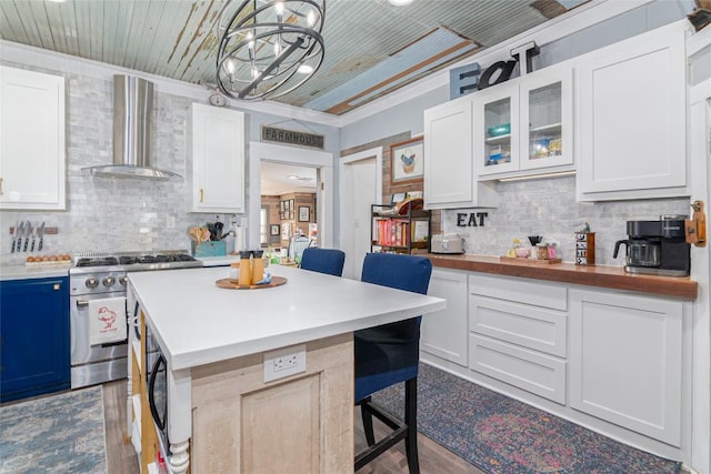 kitchen with decorative backsplash, black microwave, a breakfast bar, wall chimney range hood, and stainless steel range
