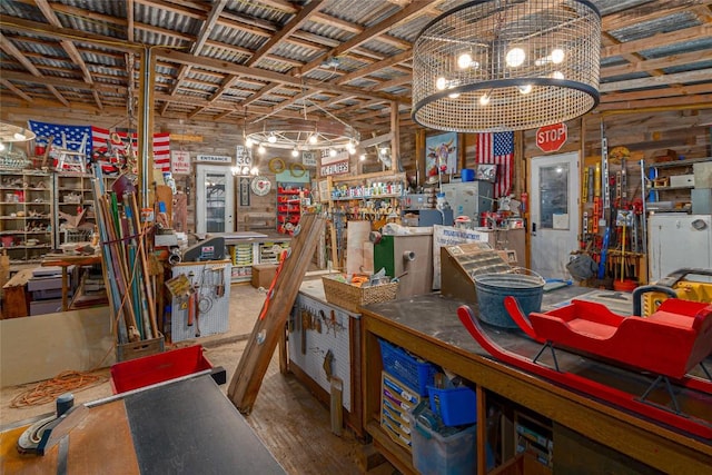 basement with a workshop area, wood finished floors, and a notable chandelier