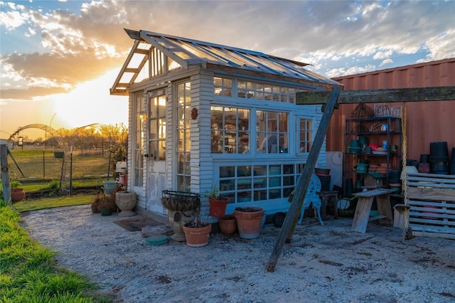 outdoor structure at dusk with an outbuilding