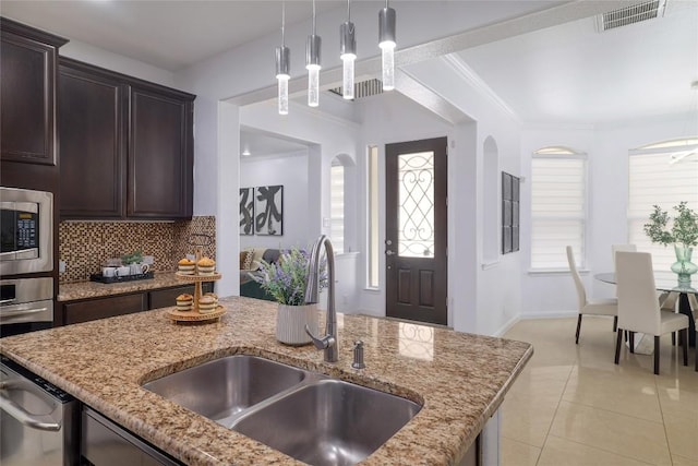 kitchen featuring dark brown cabinetry, visible vents, pendant lighting, appliances with stainless steel finishes, and a sink