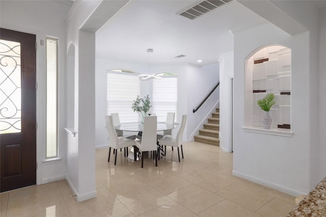 foyer featuring light tile patterned floors, baseboards, and visible vents