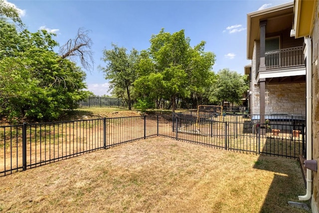 view of yard with a fenced backyard and a balcony