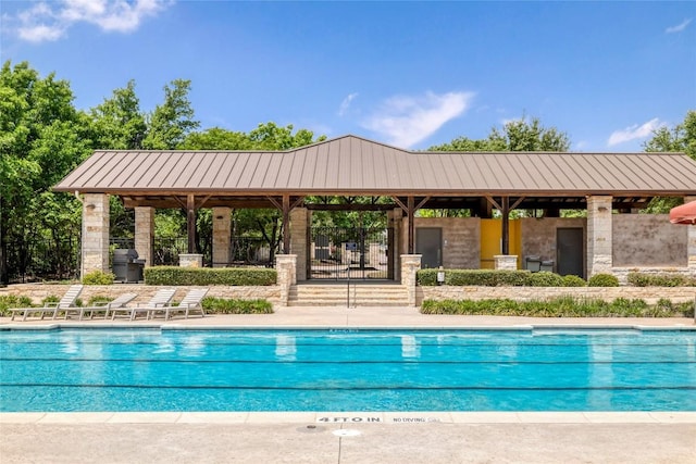 pool with a gazebo and area for grilling