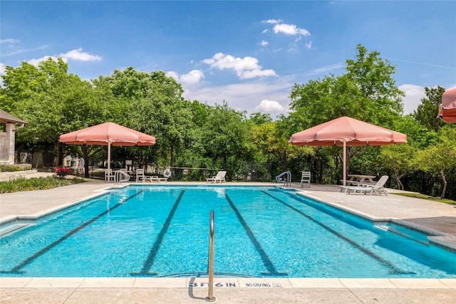 community pool featuring fence and a patio area