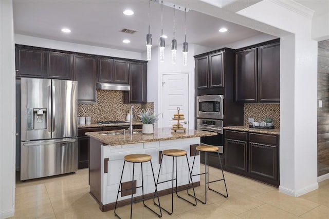 kitchen featuring visible vents, a breakfast bar, tasteful backsplash, stone counters, and appliances with stainless steel finishes