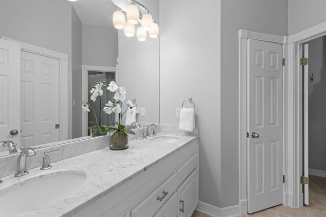 1901 Plantation Ct, Round Rock, TX 78681 - bathroom with double vanity, a chandelier, tile patterned floors, and baseboards