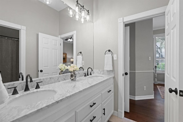 1901 Plantation Ct, Round Rock, TX 78681 - full bathroom with double vanity, wood finished floors, baseboards, and a ceiling fan