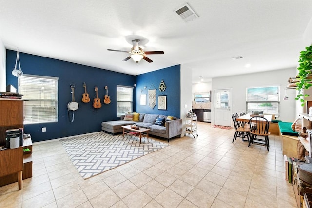 living area with a ceiling fan, visible vents, and a healthy amount of sunlight