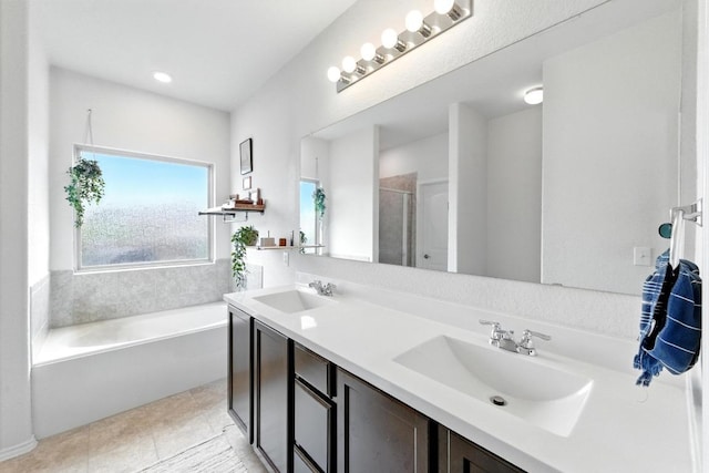 bathroom with a sink, double vanity, a stall shower, and a garden tub