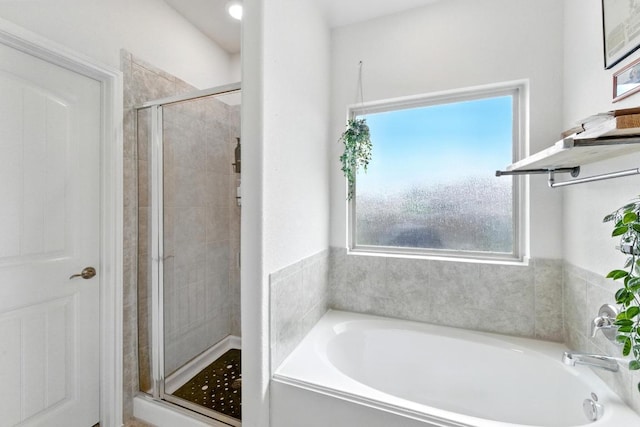 full bath with a stall shower and a garden tub