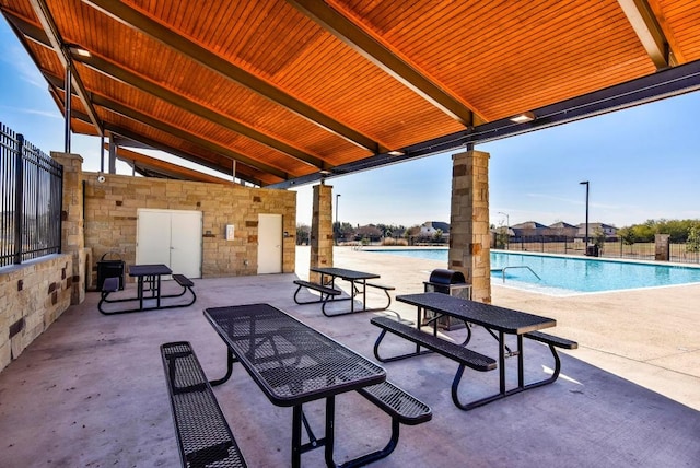 view of patio / terrace with a community pool and fence