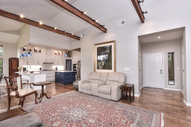 300 San Gabriel Village Blvd Unit 523, Georgetown, TX 78626 - living area featuring dark wood-style floors, baseboards, beamed ceiling, and high vaulted ceiling