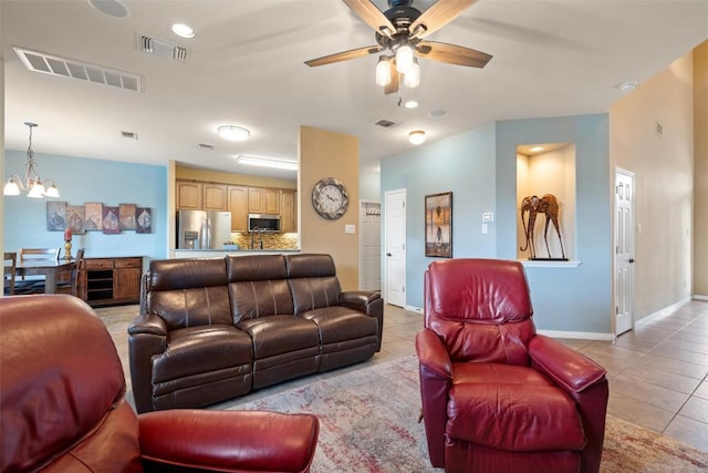 6006 Seville Dr, Austin, TX 78724 - living area with light tile patterned flooring, ceiling fan, and a chandelier
