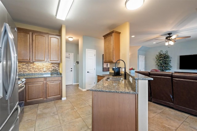 6006 Seville Dr, Austin, TX 78724 - kitchen featuring a peninsula, stainless steel appliances, open floor plan, tasteful backsplash, and dark stone countertops