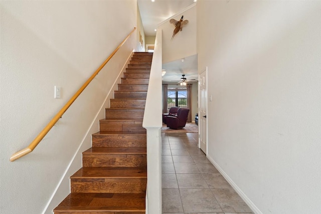 6006 Seville Dr, Austin, TX 78724 - stairway featuring baseboards, tile patterned flooring, a ceiling fan, and a high ceiling