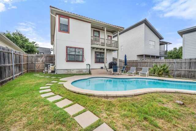 6006 Seville Dr, Austin, TX 78724 - rear view of property featuring a balcony, a fenced backyard, stucco siding, and a patio