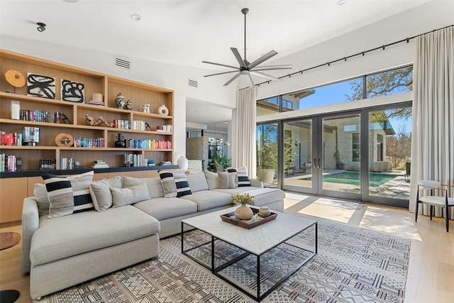 8701 Acuarela Ct, Austin, TX 78735 - living room featuring french doors, wood finished floors, ceiling fan, and a high ceiling