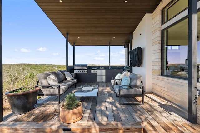wooden deck with exterior kitchen, grilling area, and outdoor lounge area