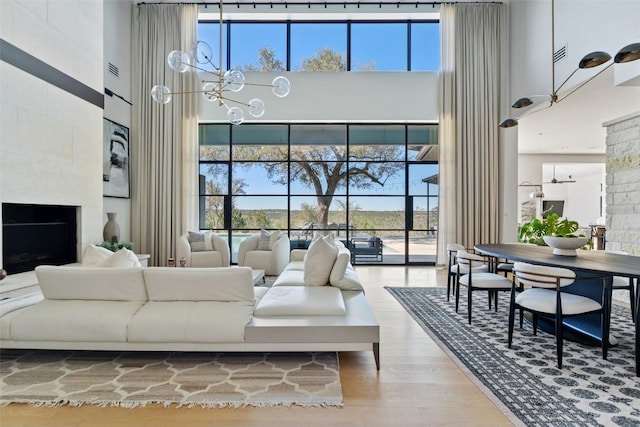 living room with a high ceiling, wood finished floors, and a wealth of natural light