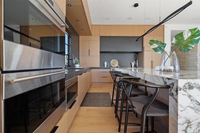 8701 Acuarela Ct, Austin, TX 78735 - kitchen with modern cabinets, light brown cabinets, appliances with stainless steel finishes, tasteful backsplash, and recessed lighting