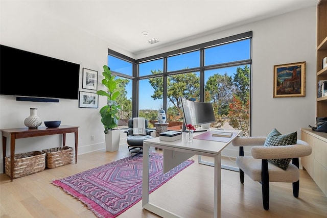 office space with wood finished floors and visible vents