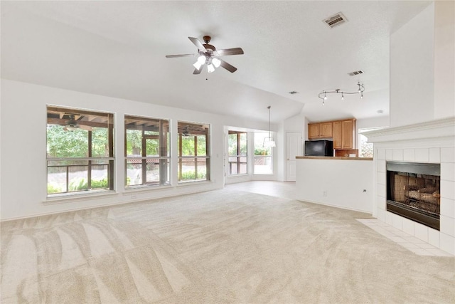 1202 Stepp Bnd, Cedar Park, TX 78613 - unfurnished living room featuring a ceiling fan, lofted ceiling, light colored carpet, a tiled fireplace, and track lighting