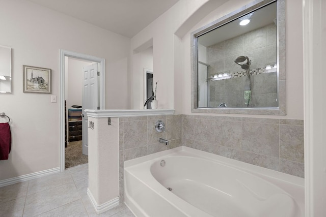 bathroom featuring a garden tub, baseboards, tile patterned flooring, and a tile shower